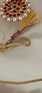 A gold colored cord with a purple and red string.